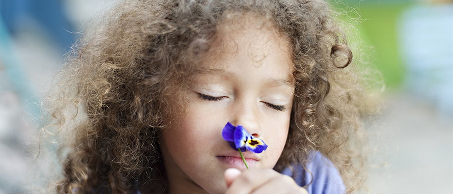 Ett barn som luktar på en blomma