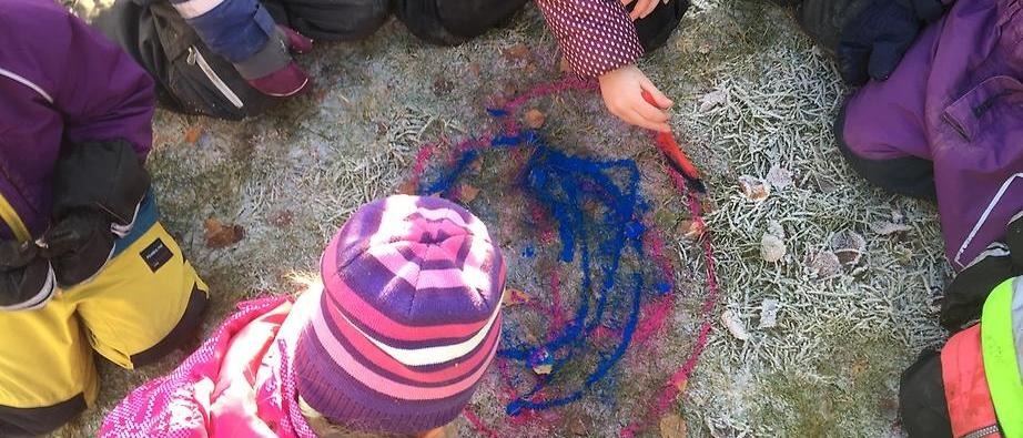 Flera barn som målar på marken