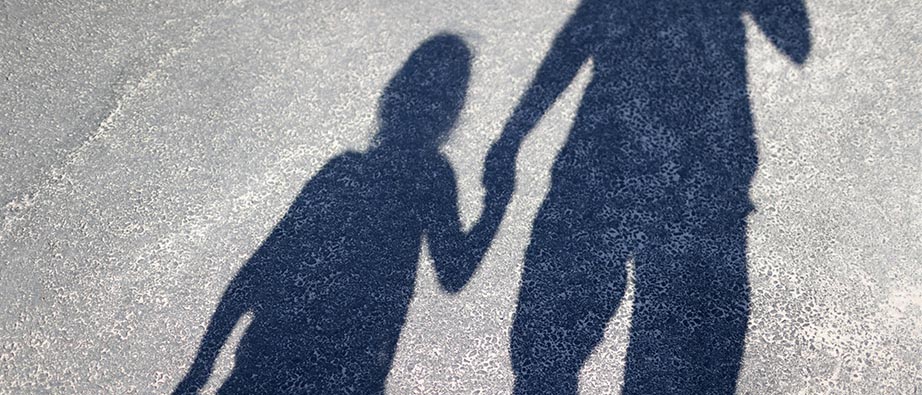 Skuggan av två personer som går och håller varandra i handen