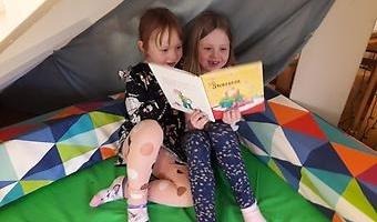 två barn läser bok
