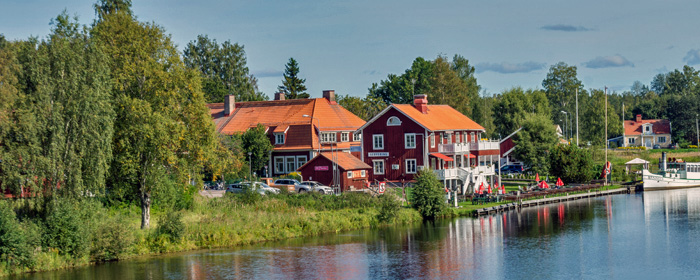 Bild över dalälven med Torsångs café där man även ser en ångbåt förtöjd