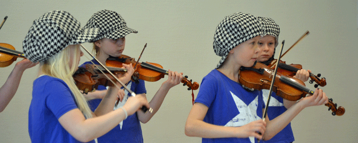 Fyra barn spelar fiol och har rutiga kepsar och blå t-shirts på sig