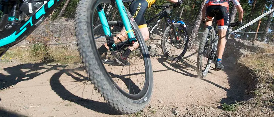 Bild på hjulen på flera mountainbikecyklar på en grusad stig.