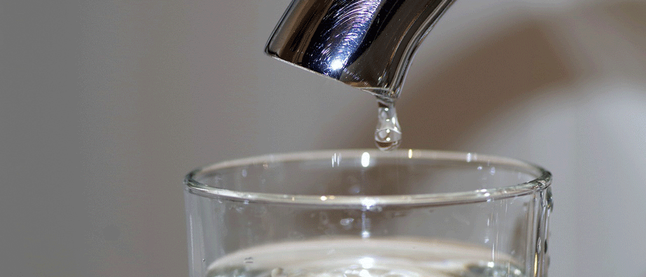 En droppe vatten som rinner från en kran