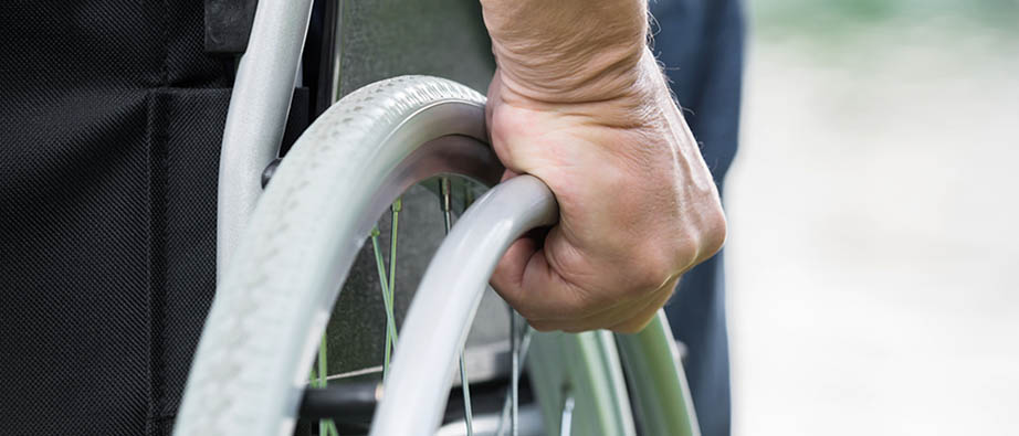 Arm och hand syns på en man som sitter i rullstol