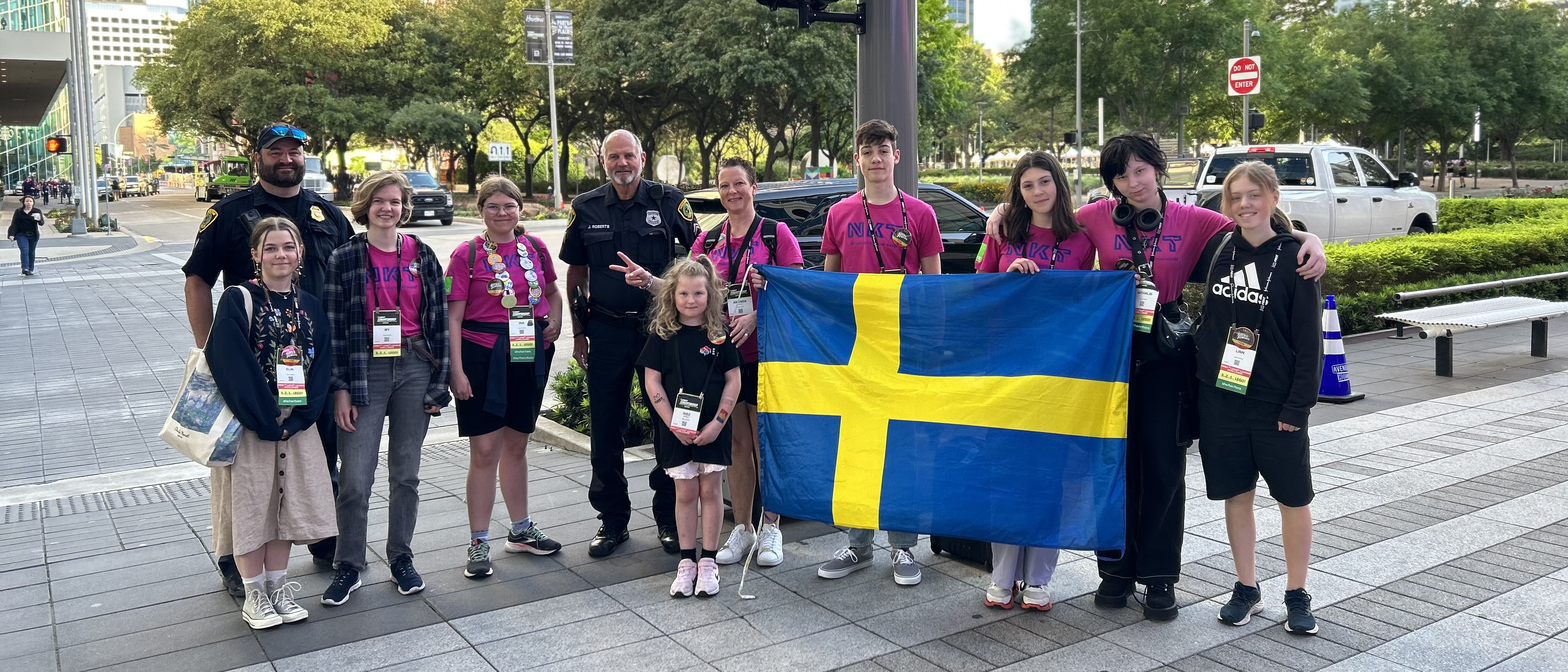 Flera människor på rad med en stor svensk flagga