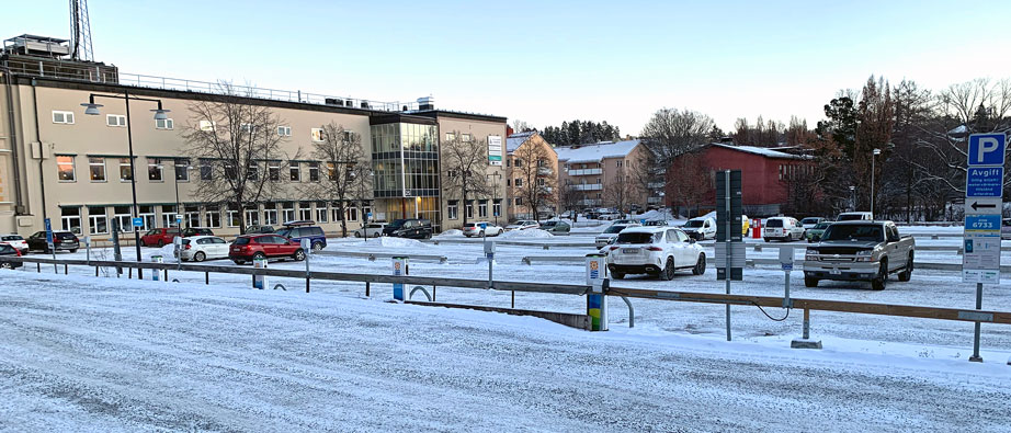 Bild på Gamla Postenparkeringen med bilar parkerade på snöigt underlag