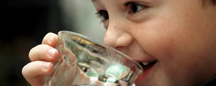 barn som dricker vatten ur ett glas