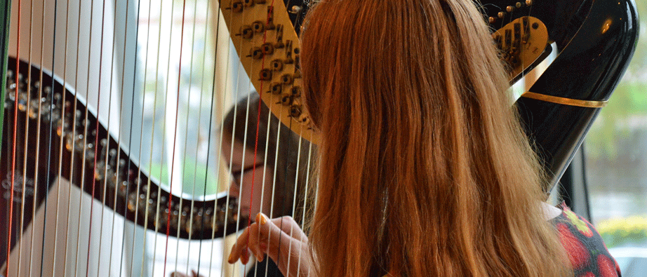 Två tjejer sitter vid var sin harpa, närbild