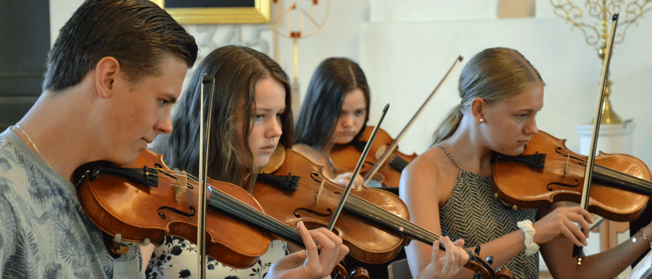 Fem ungdomar spelar fiol i ett kyrkorum