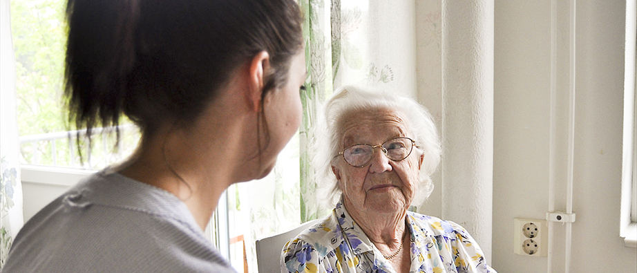 En pensionär får hjälp i hemmet av hemtjänstpersonal
