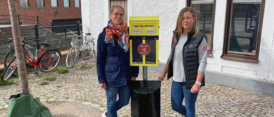 Anna Rogström och Caroline Lindqvist vid gul fimpbehållare.