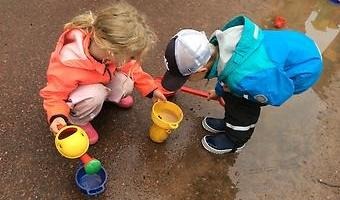 Barn som leker ute i vattenpölar