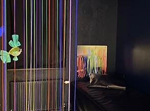Ett svart rum med inslag av färgglada material
