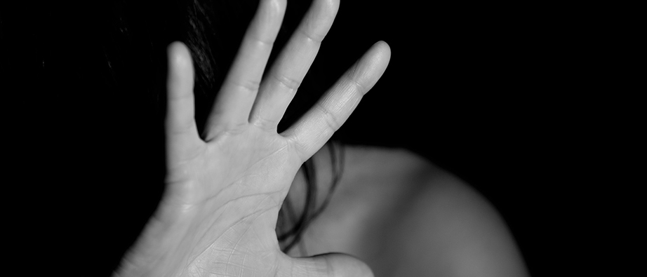 En svart-vit bild där någon sätter upp en hand för sitt ansikte.