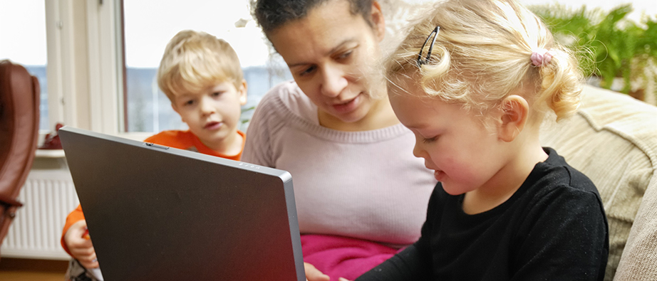 Föräldrar och barn som tittar på en dataskärm