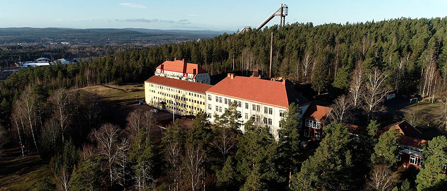 Flygbild som visar gamla sanatoriebyggnaden på Högbo. i Bakgrunden syns skog och hoppbacken