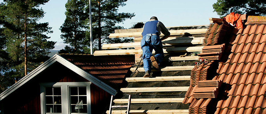 En hantverkare som är på ett tak och jobbar