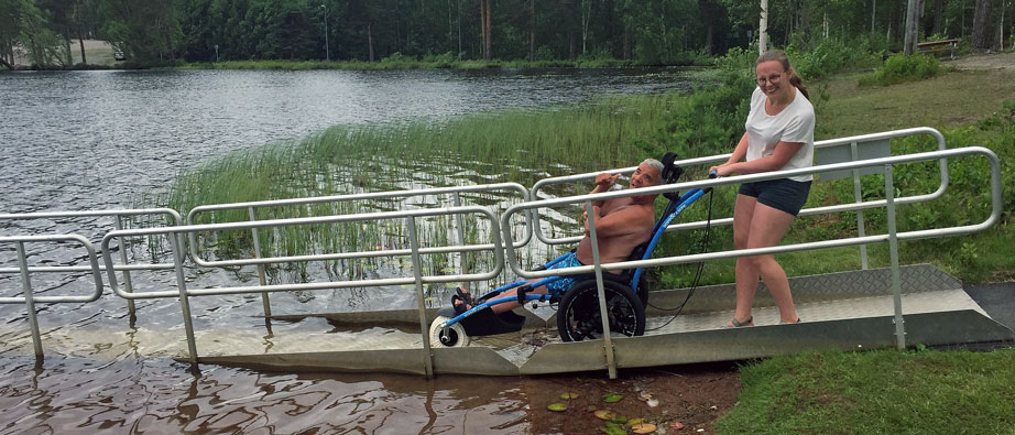 En person i rullstol vid vatten.