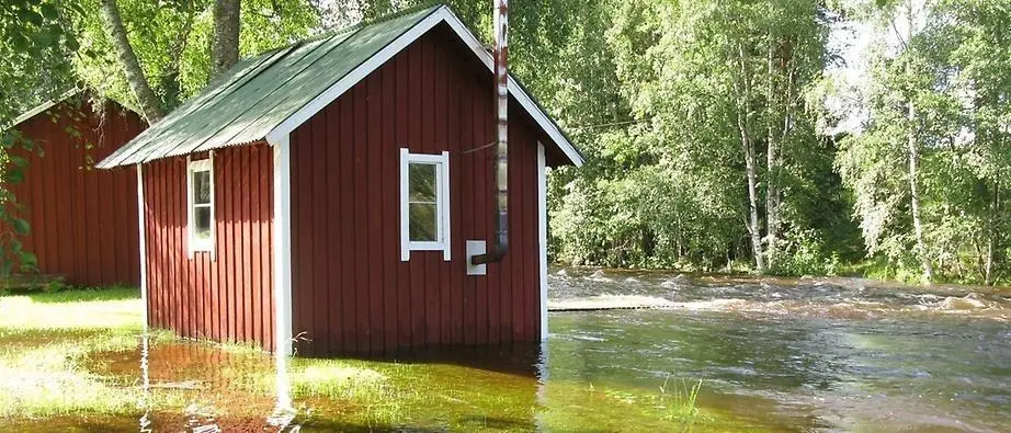 Översvämning vid ett litet hus.