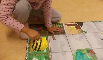 Barn programmerar roboten Bee-Boot