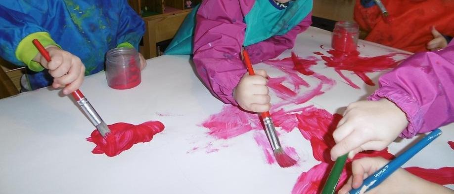 Barnen målar med röd färg