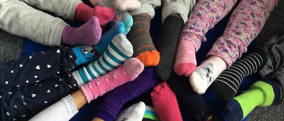 En massa barns fötter med färgglada strumpor