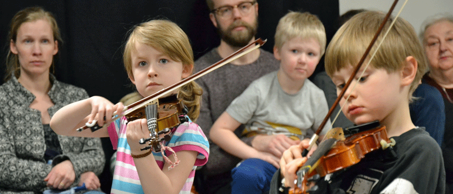 Två barn spelar på små fioler
