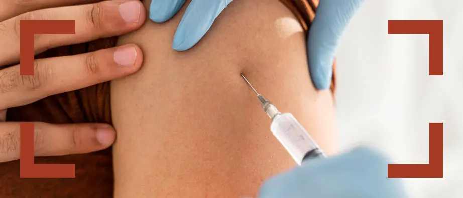Bild som visar när en vaccinspruta sticks in i en arm