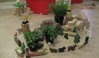Barns verk mitt i ett rum, med leksaker och växter.