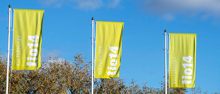 Kulturhusets gröna flaga med loggan på vajar i vinden.