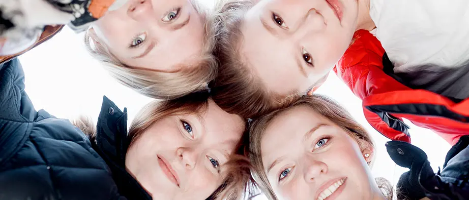 Fyra barn som tittar ner mot kameran som fotar underifrån