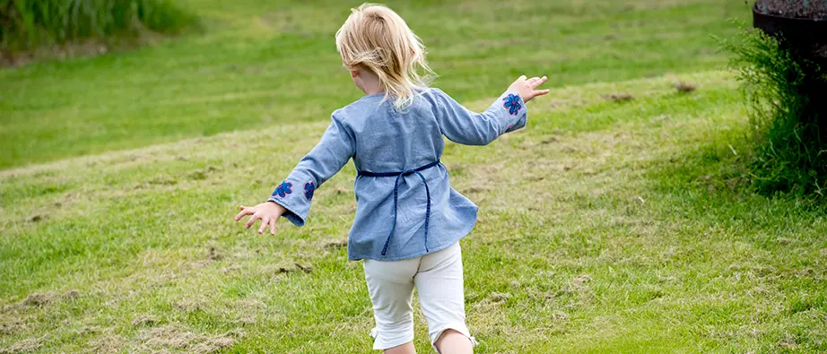 Ett barn som springer på gräset