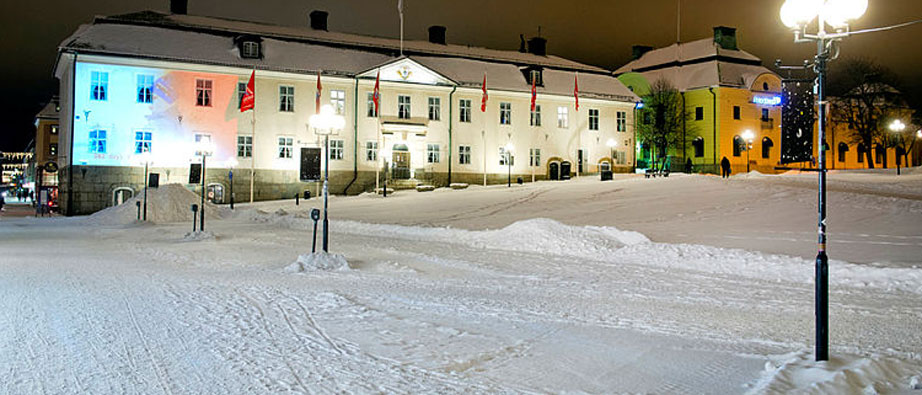 Stora Torget med snö på sig och det vita Rådhuset är upplyst på kvällen.