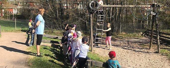 Barn och pedagoger leker utomhus